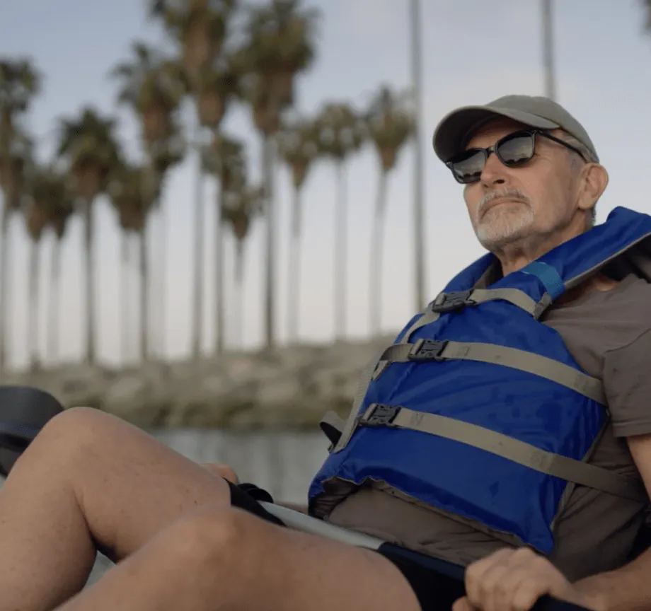 Joel sitting in a kayak surrounded by palm trees